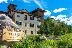 Vail apartment for rent - A large rock with a sign that says Middle Creek at Vail in front of a building.