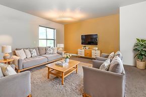Vail apartment for rent - A living room with a grey couch, a wooden coffee table, and a television.