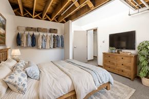 Denver apartment for rent - a bedroom with a bed and a dresser and a tv