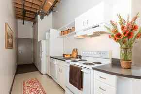 Denver apartment for rent - a kitchen with white appliances and a vase of flowers