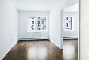 Bronx apartment for rent - an empty room with wood floors and two windows
