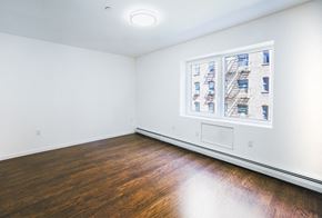 Bronx apartment for rent - an empty room with wood floors and a window