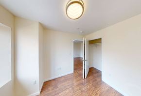 Bronx apartment for rent - a renovated living room and hallway with wood flooring and a closet