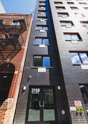 Bronx apartment for rent - a tall brick building with a black door and windows
