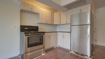 Bronx apartment for rent - A kitchen with a stainless steel refrigerator and oven.