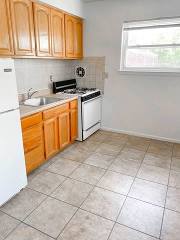 Irvington apartment for rent - A kitchen with wooden cabinets and a white refrigerator.