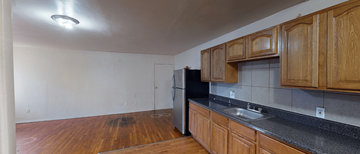 Irvington apartment for rent - A kitchen with wooden cabinets and a black refrigerator.