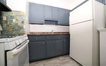 Irvington apartment for rent - A kitchen with a white refrigerator and a stove with a white top.