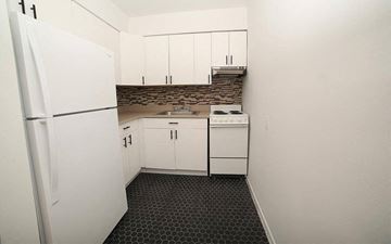 Irvington apartment for rent - A kitchen with white cabinets and a black and white floor.
