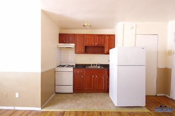 East Orange apartment for rent - a small kitchen with white appliances and wooden cabinets