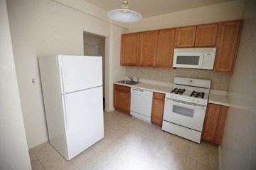 East Orange apartment for rent - a kitchen with white appliances and wooden cabinets