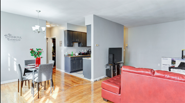 Irvington apartment for rent - A living room with a red couch and a dining table with chairs.