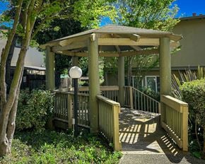 Castro Valley townhouse for rent - A wooden gazebo with a white ball on top is surrounded by greenery.