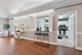 Jacsksonville apartment for rent - A kitchen with a bar stool and a table in front of a window.
