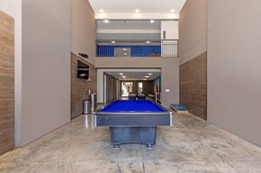 Fort Worth apartment for rent - A pool table is in the middle of a room with a balcony in the background.