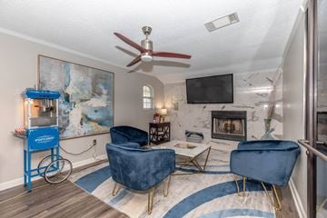 Waxahachie apartment for rent - A living room with a blue chair and a fan.
