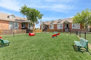 Waxahachie apartment for rent - A grassy area with benches and a red object in the middle.