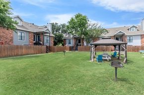 Waxahachie apartment for rent - A backyard with a wooden fence and a gazebo.