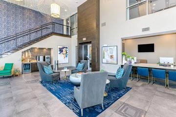 Dallas apartment for rent - A living room with a blue rug and grey chairs.
