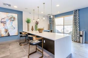 Dallas apartment for rent - A modern kitchen with a white countertop and gold bar stools.