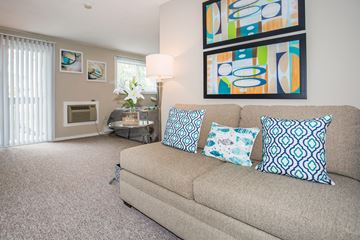 East Haven apartment for rent - A living room with a couch, pillows, and a painting on the wall.