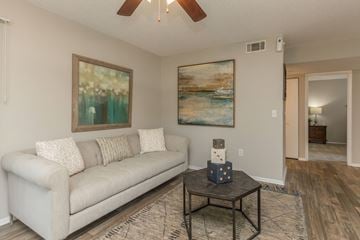 Apopka apartment for rent - A living room with a couch, a coffee table, and two paintings on the wall.