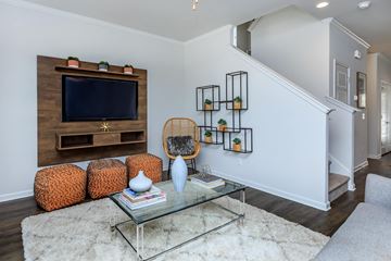 Savannah apartment for rent - A living room with a glass coffee table and a wooden entertainment unit.