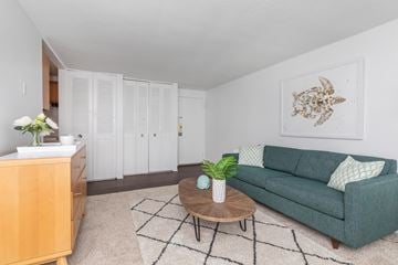 New London apartment for rent - A living room with a green couch, a wooden coffee table, and a painting on the wall.