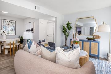 Richmond Hill apartment for rent - A living room with a large couch and a mirror on the wall.