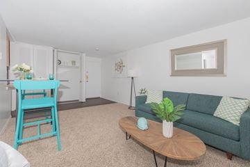 New London apartment for rent - A blue chair sits in a living room with a couch and a coffee table.