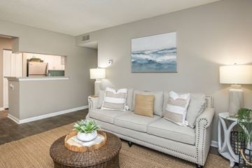 Atlantic Beach apartment for rent - A living room with a white couch, a brown coffee table, and a painting on the wall.