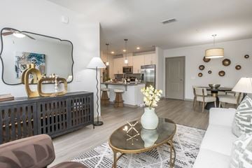 Jacksonville apartment for rent - A modern living room with a glass coffee table and a large mirror on the wall.