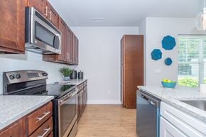 Simsbury apartment for rent - A kitchen with a white counter top and wooden cabinets.