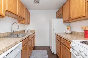 New London apartment for rent - A kitchen with wooden cabinets and white appliances.