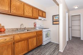 Rocky Hill apartment for rent - A kitchen with wooden cabinets and a white stove top oven.