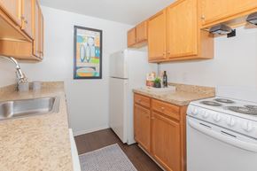 New London apartment for rent - A kitchen with a white stove and wooden cabinets.