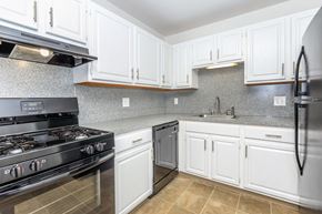 West Haven apartment for rent - A kitchen with white cabinets and a black stove top oven.