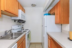 East Haven apartment for rent - A kitchen with white appliances and wooden cabinets.