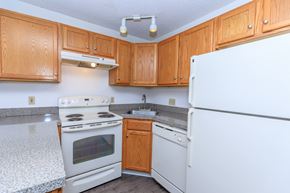 Waterbury apartment for rent - A kitchen with wooden cabinets and white appliances.