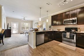 Yulee apartment for rent - A kitchen with dark brown cabinets and stainless steel appliances.