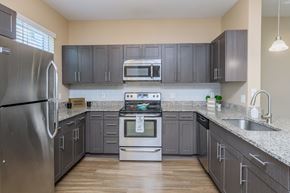 Bradenton apartment for rent - A kitchen with a stainless steel refrigerator and a stainless steel oven.