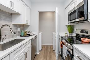 St. Petersburg apartment for rent - A kitchen with white cabinets and a black stove top.