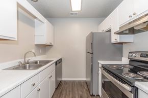 Waxahachie apartment for rent - A kitchen with white cabinets and stainless steel appliances.