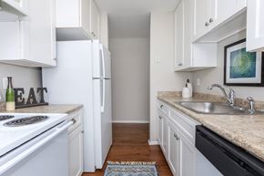 Naugatuck apartment for rent - A kitchen with white cabinets and a black dishwasher.