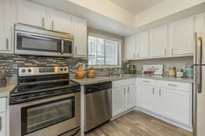 Apopka apartment for rent - A kitchen with white cabinets and stainless steel appliances.