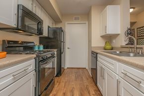 Riverview apartment for rent - A kitchen with white cabinets and a black refrigerator.