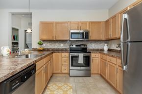 Manchester apartment for rent - A kitchen with wooden cabinets and a stainless steel refrigerator.