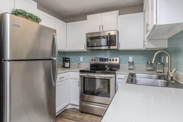 Atlantic Beach apartment for rent - A kitchen with a stainless steel refrigerator and white cabinets.