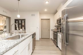 Jacksonville apartment for rent - A modern kitchen with a stainless steel refrigerator and white cabinets.