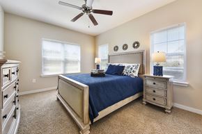 Yulee apartment for rent - A bedroom with a bed, dresser, and ceiling fan.